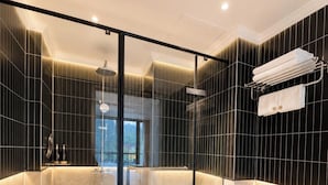 Ein modernes Badezimmer mit einer Duschkabine aus Glas, einer Marmorarbeitsplatte und Blick auf einen Balkon.