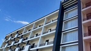 A multi-story hotel building with balconies and a clear sky. - Reikartz Termez Palace (Farg'ona)