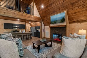 A cozy interior with a kitchen, dining area, and fireplace. - Brand new three bedroom three bathroom A-Frame Cabin (Sevierville)