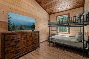 A cabin interior with a bunk bed, a dresser, and a painting of a landscape. - Brand new three bedroom three bathroom A-Frame Cabin (Sevierville)