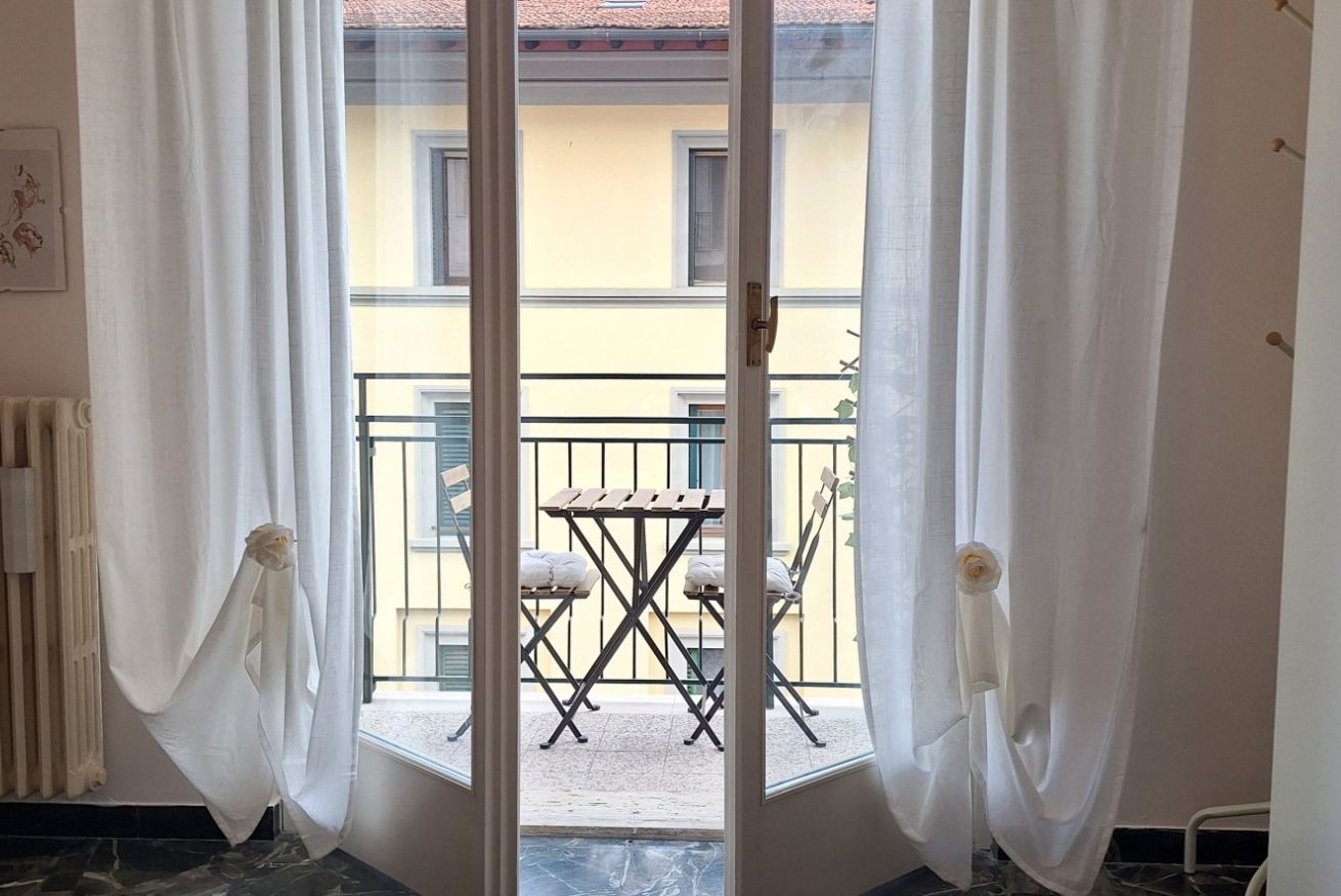 Une chambre avec vue sur un balcon, une table et des chaises.