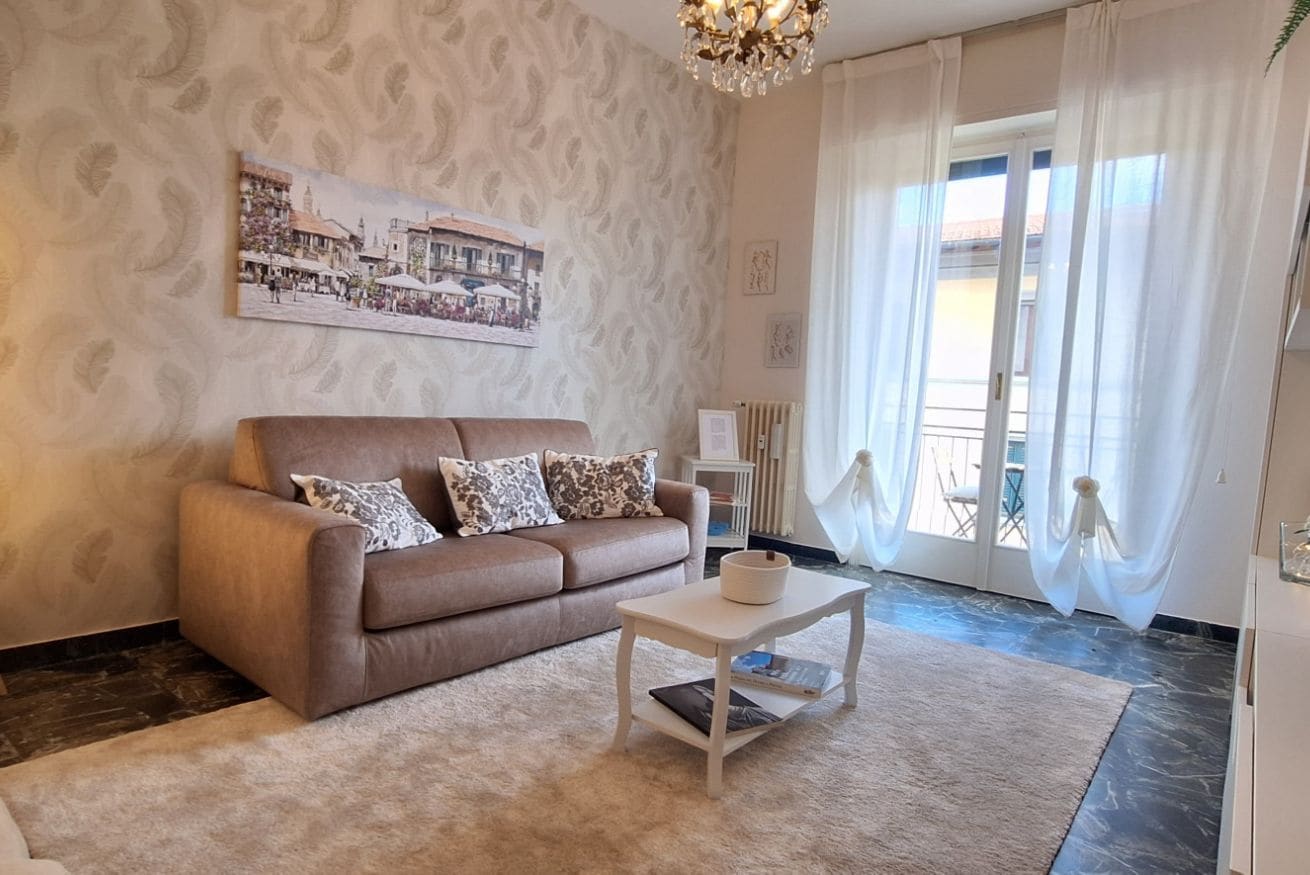 Un salon avec un canapé marron, une table basse blanche et un mur orné d’un motif.