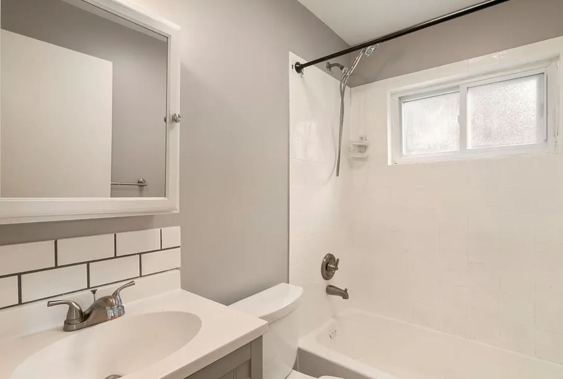 Un baño con lavamanos blanco, inodoro y bañera.