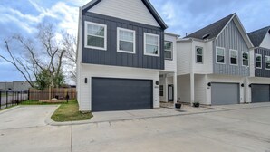 A modern two-story house with a dark gray exterior, white trim, and a garage. - Gated 3BR Home, Garage + Fenced Backyard, 15 Min to Galleria & Downtown (Houston)