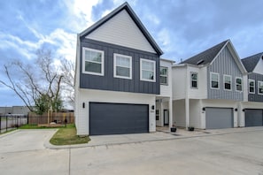 A modern two-story house with a dark gray exterior, white trim, and a garage. - Gated 3BR Home, Garage + Fenced Backyard, 15 Min to Galleria & Downtown (Houston)