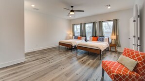 A bedroom with two beds, a ceiling fan, and a red couch. - Gated 3BR Home, Garage + Fenced Backyard, 15 Min to Galleria & Downtown (Houston)