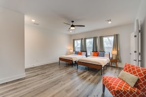 A bedroom with two beds, a ceiling fan, and a red couch. - Gated 3BR Home, Garage + Fenced Backyard, 15 Min to Galleria & Downtown (Houston)