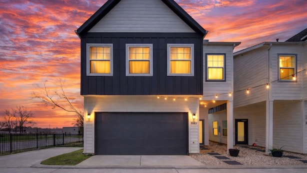 A two-story house with a dark roof, white siding, and a garage. - Gated 3BR Home, Garage + Fenced Backyard, 15 Min to Galleria & Downtown (Houston)