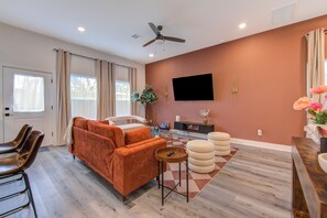 A modern living room with a sofa, chairs, a TV, and a ceiling fan. - Gated 3BR Home, Garage + Fenced Backyard, 15 Min to Galleria & Downtown (Houston)