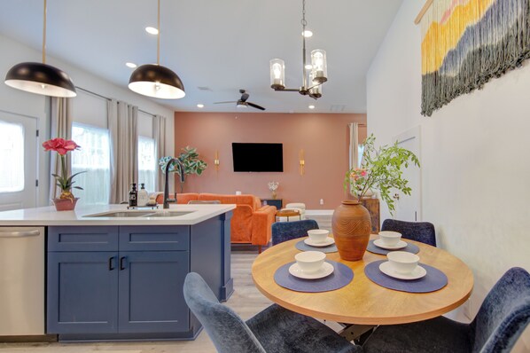A modern kitchen with blue cabinets, a wooden dining table, and a ceiling fan. - Gated 3BR Home, Garage + Fenced Backyard, 15 Min to Galleria & Downtown (Houston)