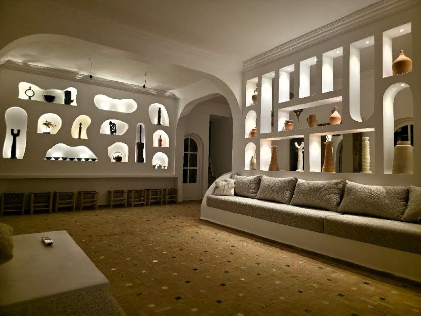 Une pièce comprenant un canapé, des fauteuils et un mur orné de divers objets.