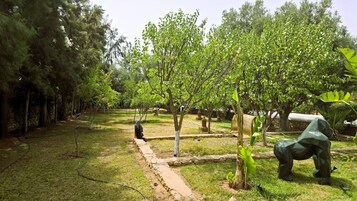 Un jardín con varios árboles y una estatua.
