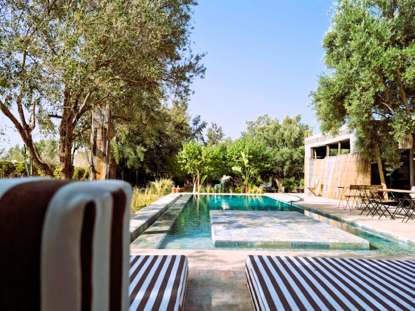 A pool area with lounge chairs and a view of the surrounding landscape.