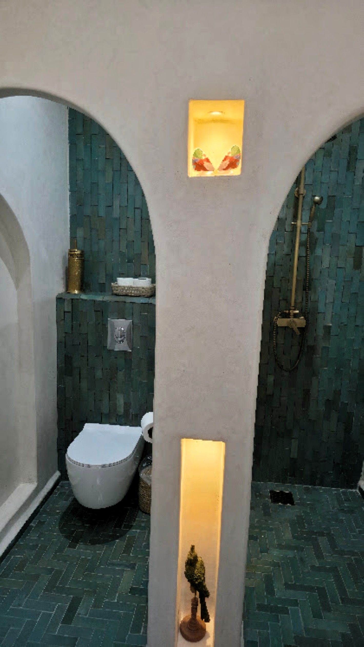 Un baño con inodoro blanco, lavabo y zona de ducha.