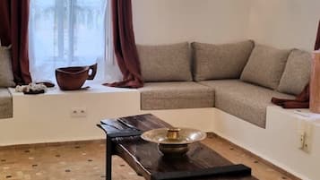 Uma sala de estar aconchegante com sofá seccional, mesa de centro e luminária de parede decorativa.