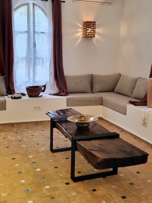 A cozy living room with a sectional sofa, a coffee table, and a decorative wall light.
