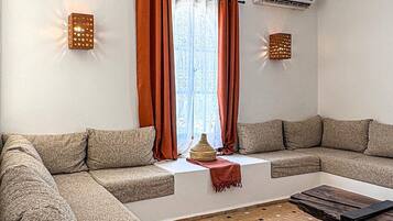 Un salon moderne avec un canapé d’angle, une table basse et un sol à motifs.