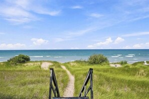 A pathway leading to a beach with the ocean in the background.