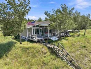 A house with a porch, a flag, and a grassy yard.