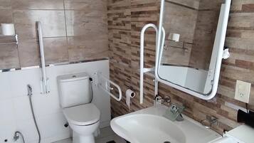 A modern bathroom with a toilet, sink, and mirror.