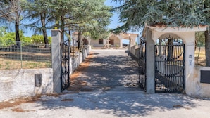A gated entrance with a pathway leading to a building. - Villa Latina with Private Veranda, Wi-Fi, and Air Conditioning (Solarino)