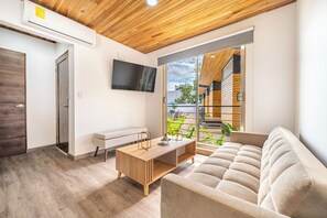 A modern living room with a sofa, a coffee table, and a TV mounted on the wall. - Luxurious 6-unit Oasis < 1 Mi to Playas Del Coco! (Sardinal)