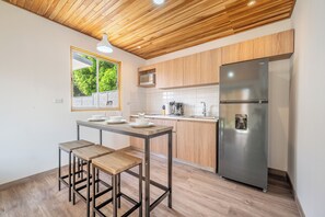 A modern kitchen with a wooden ceiling, a stainless steel refrigerator, and a dining area with stools. - Luxurious 6-unit Oasis < 1 Mi to Playas Del Coco! (Sardinal)