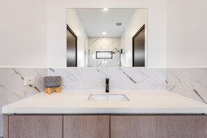 A bathroom with a white marble countertop, a black faucet, and a small wooden stool. - Walk to Beach! Tamarindo Home w/ Private Pool (Tamarindo)
