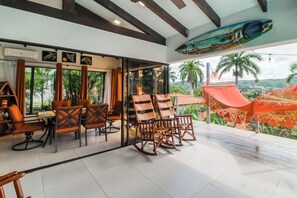 Quarto com área de jantar, rede e vista para a paisagem.