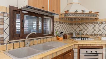 A kitchen with a double sink, a stove, and a built-in oven.