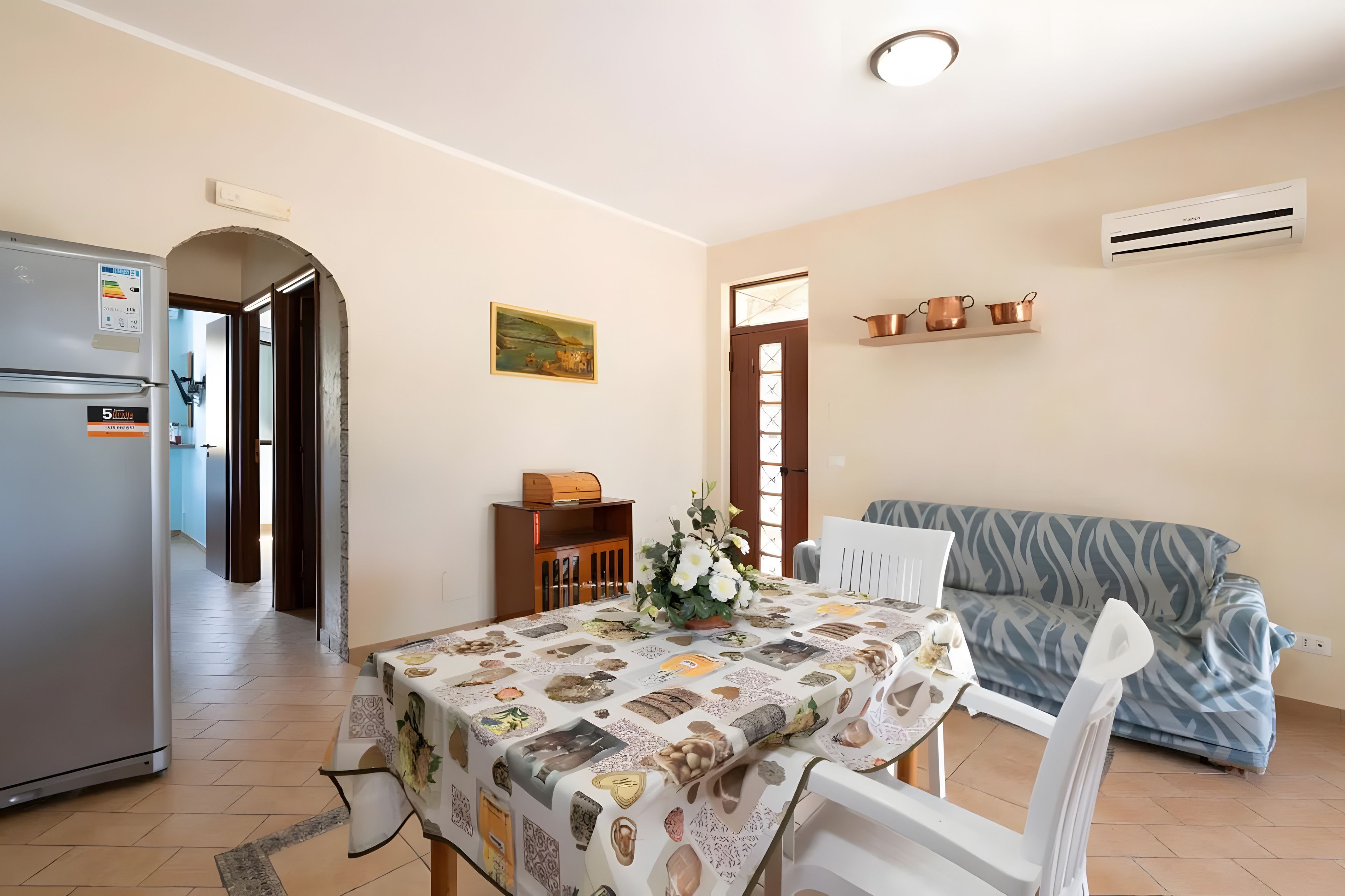 A compact living space with a dining area, kitchenette, and a sofa.