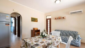 A compact living space with a dining area, kitchenette, and a sofa. - Villa Rosa with Private Pool, Wi-Fi, and Air Conditioning (Partinico)