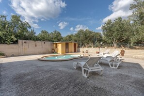 A pool area with lounge chairs and a small building, surrounded by trees and a concrete wall. - Villa Rosa With Private Pool, Wi-Fi, and Air Conditioning (Partinico)