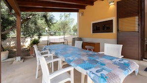 An outdoor patio with a table and chairs, a wooden ceiling, and a view of trees. - Villa Rosa with Private Pool, Wi-Fi, and Air Conditioning (Partinico)