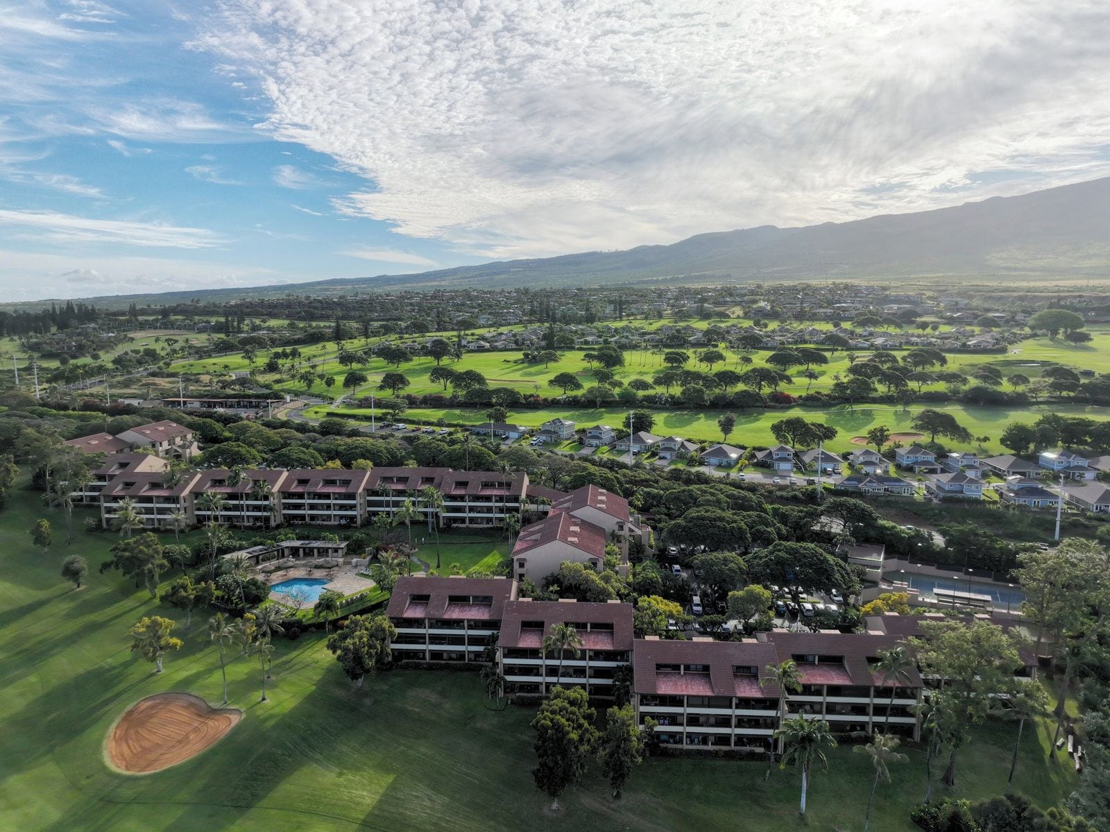 Un terrain de golf avec un complexe hôtelier en premier plan.
