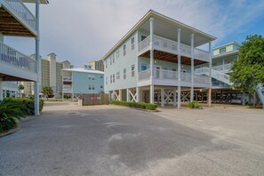Un hôtel à plusieurs étages doté de balcons, d’un espace extérieur couvert et d’un parking.