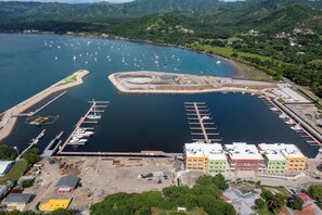 Un port esportiu amb vaixells amarrats, una zona de construcció i edificis al primer pla.