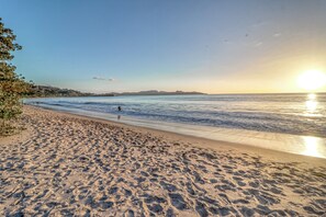 Una platja amb empremtes i un cel serè.