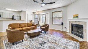 A living room with a brown leather sofa, a round coffee table, and a patterned rug. - Dog-friendly Home w/ Private Yard in Cedar Park! (Cedar Park)