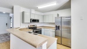 A modern kitchen with white cabinetry, stainless steel appliances, and a granite countertop. - Dog-friendly Home w/ Private Yard in Cedar Park! (Cedar Park)