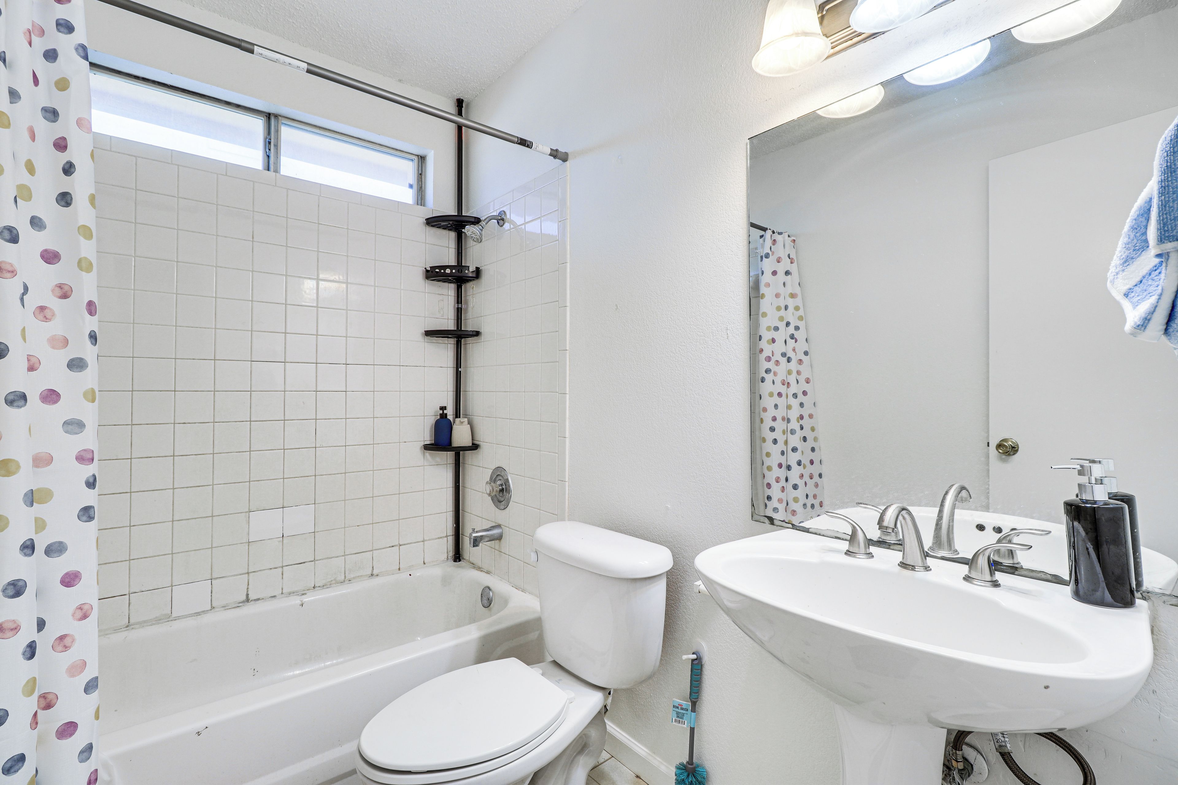 A bathroom with a bathtub, toilet, and sink.