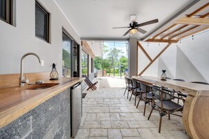 A modern kitchen with a stone countertop, a built-in dishwasher, and a ceiling fan.