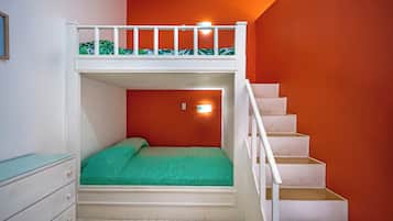 A bunk bed with a green mattress, a white dresser, and a staircase against an orange wall.