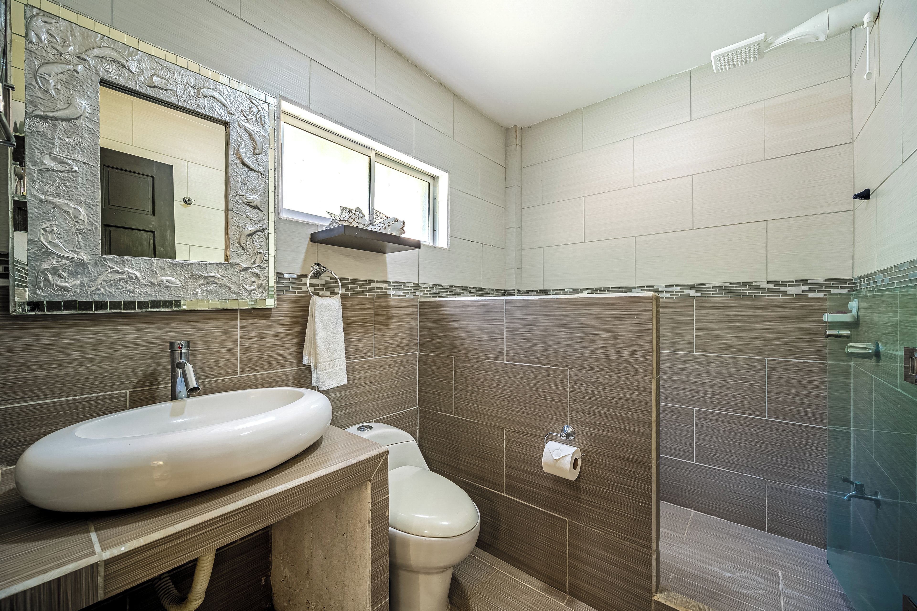 A bathroom with a large sink, toilet, and a shower area.
