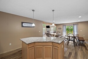 A kitchen with granite countertops, wooden cabinets, pendant lighting, and a sign that reads 'KITCHEN let's eat'. - Epic Lake Harmony Group Getaway! (Lake Harmony)