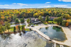 A lakeside property with a large building, a dock, and a parking area surrounded by autumn foliage. - The Ultimate Lake Harmony Group Getaway Awaits! (Lake Harmony)
