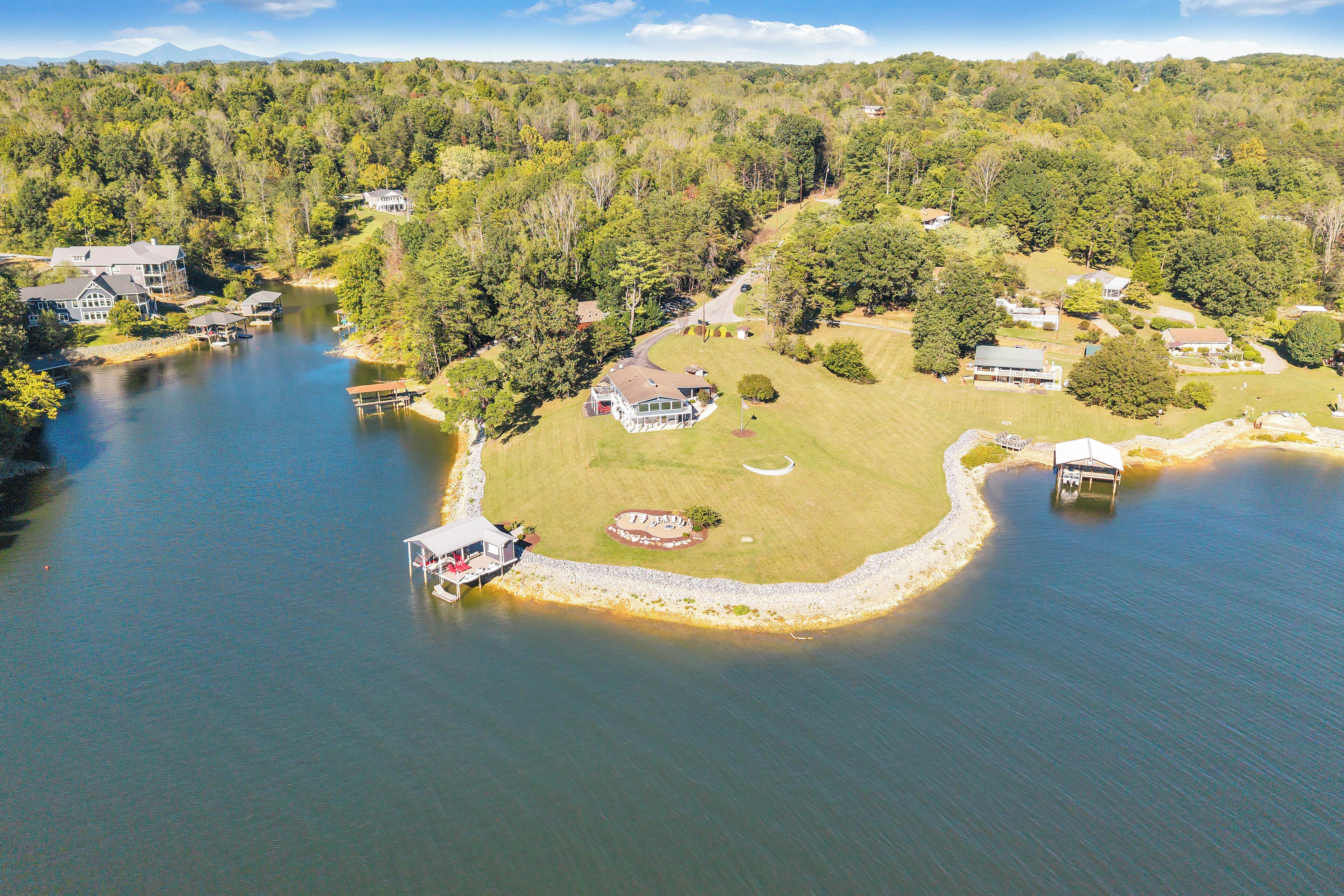 A lakeside property with a large house, dock, and boat.