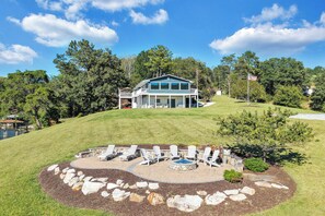 A two-story house with a covered patio area featuring outdoor seating.
