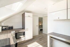 Eine moderne Küche mit Einbauofen, Mikrowelle und einem Essbereich mit Holztisch.