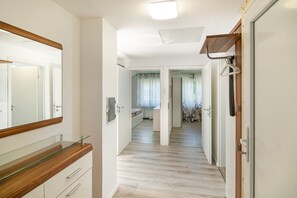 Ein Korridor mit Holzboden, weißen Wänden und einer Glastürschrank.